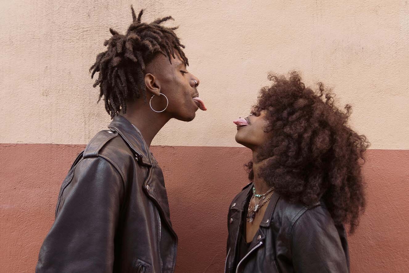 A young couple pokes their tongues out at each other. A young couple pokes their tongues out at each other.