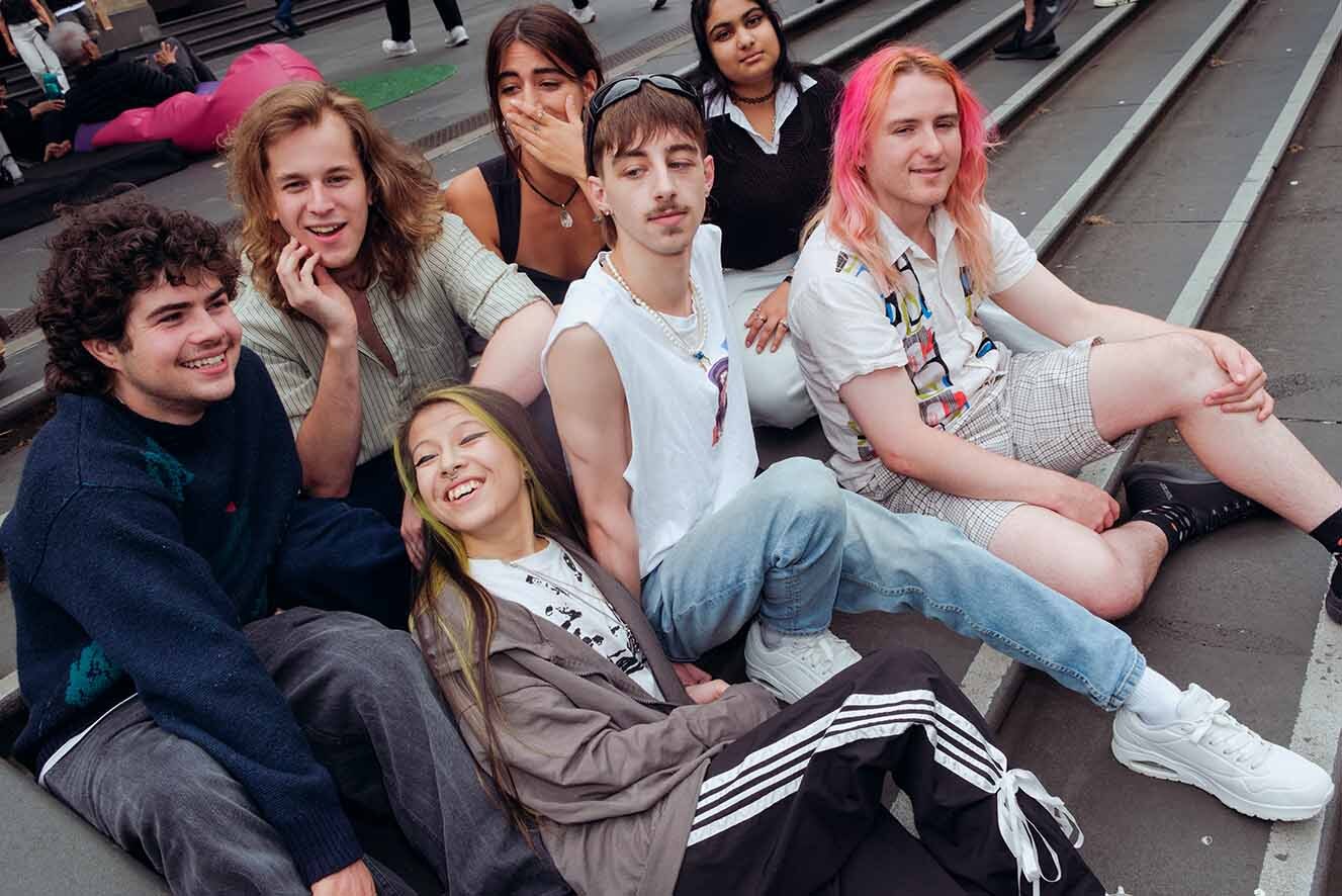 A diverse group of 7 young people sitting on steps. A diverse group of 7 young people sitting on steps.