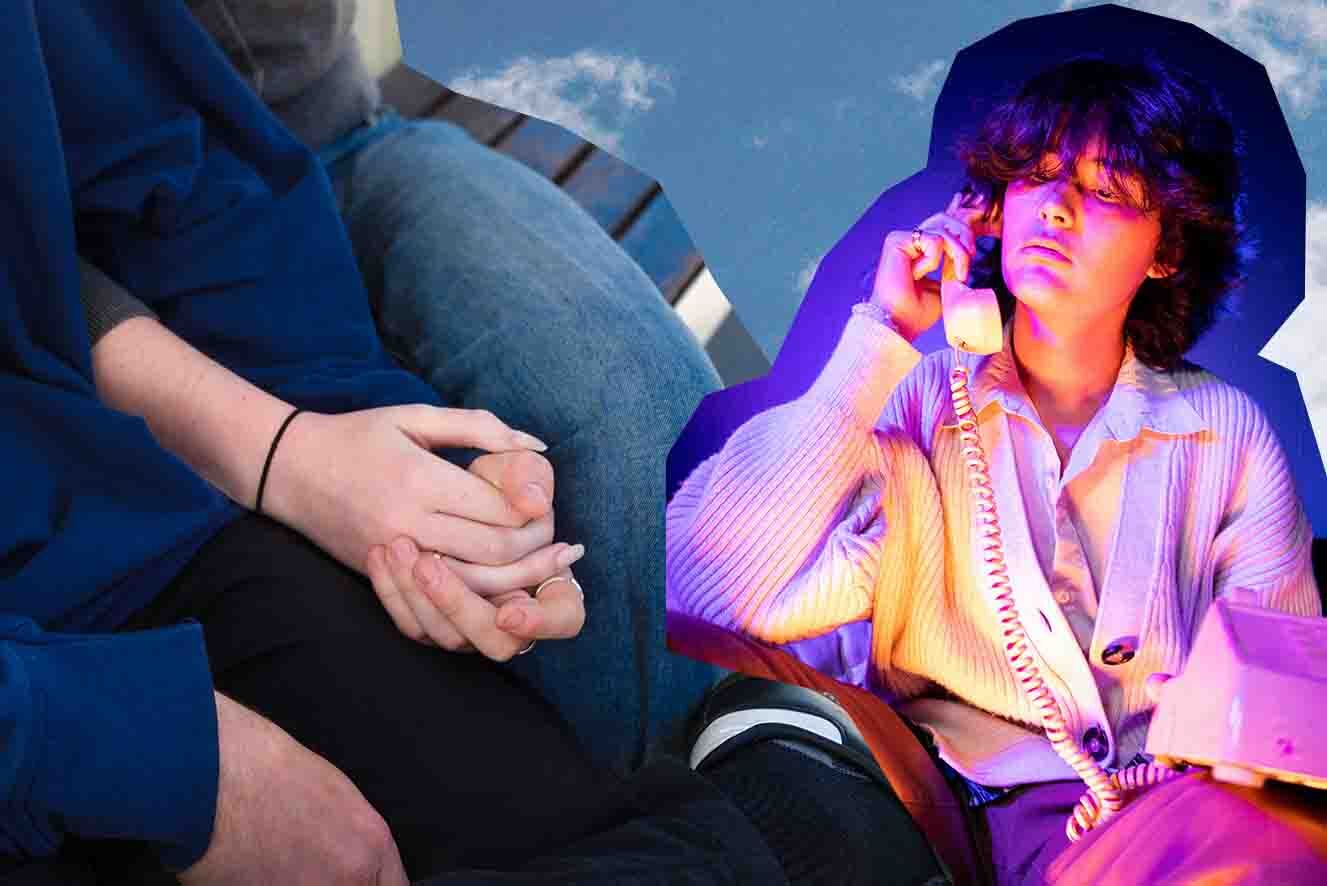 Person seated and talking on a landline phone with neon lighting, while another individual sits nearby with hands clasped.