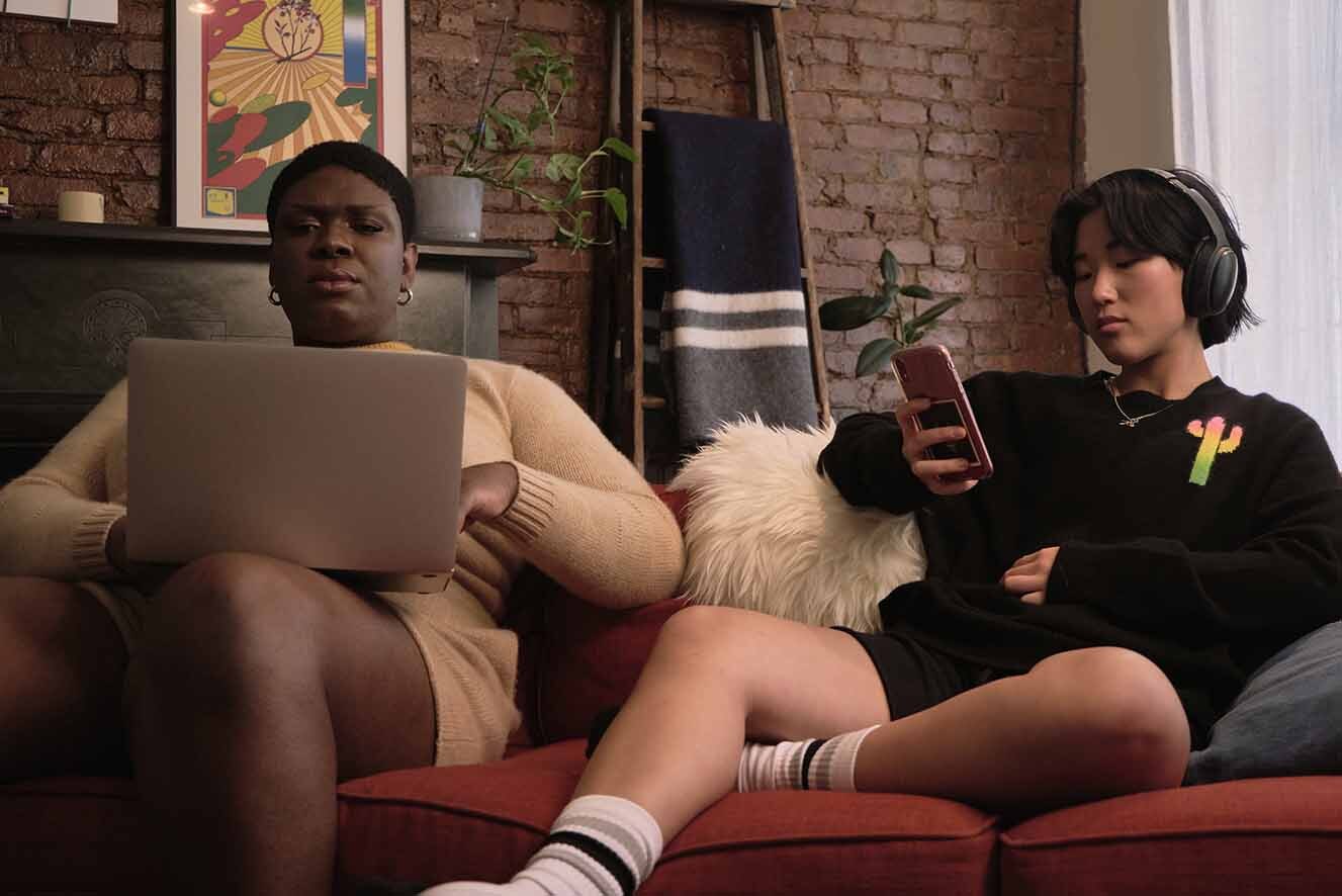 Two young people sitting on a couch. Two young people sitting on a couch.