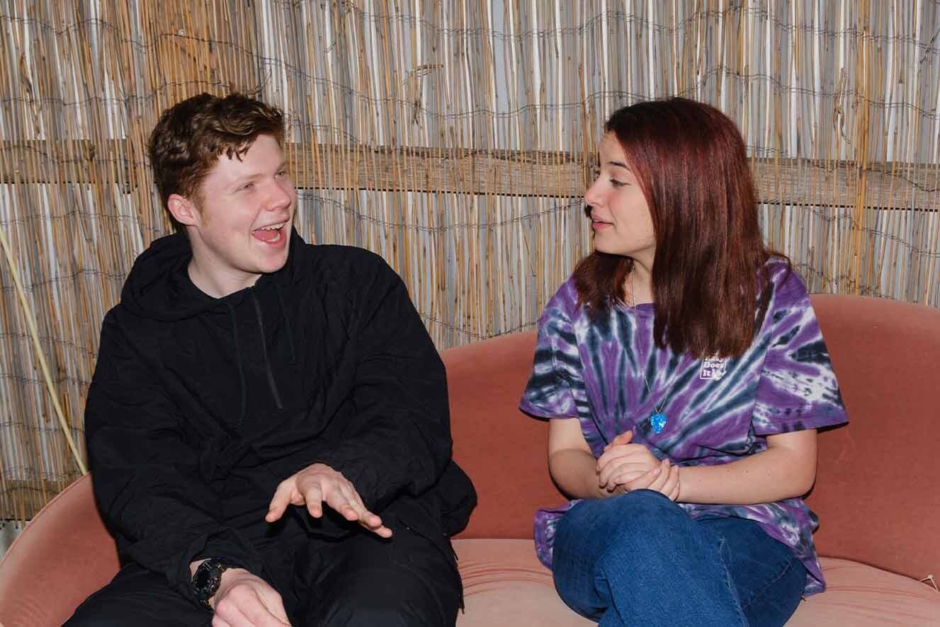 A young man and a young woman sitting on a couch. A young man and a young woman sitting on a couch.