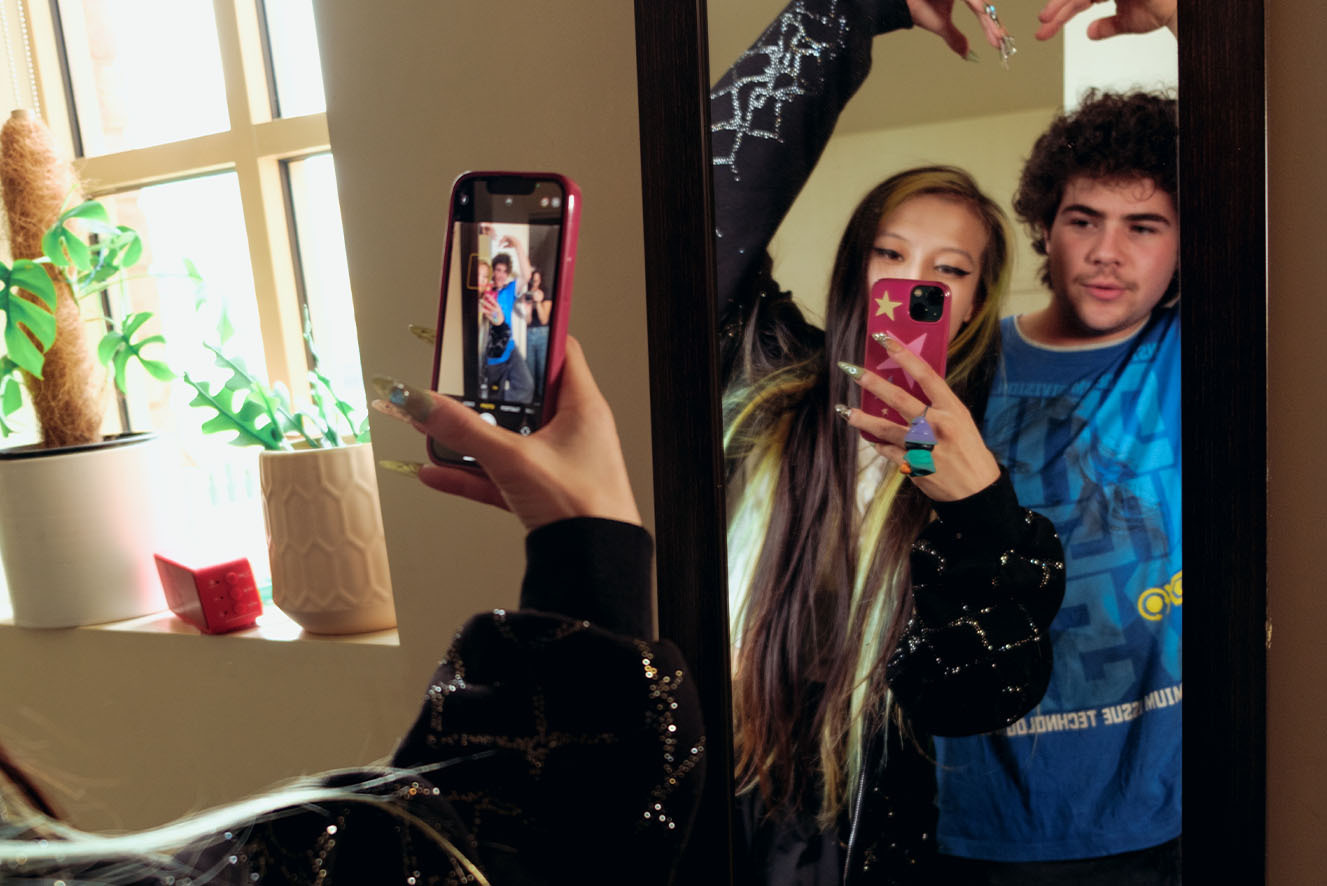 A young couple taking a mirror selfie. A young couple taking a mirror selfie.