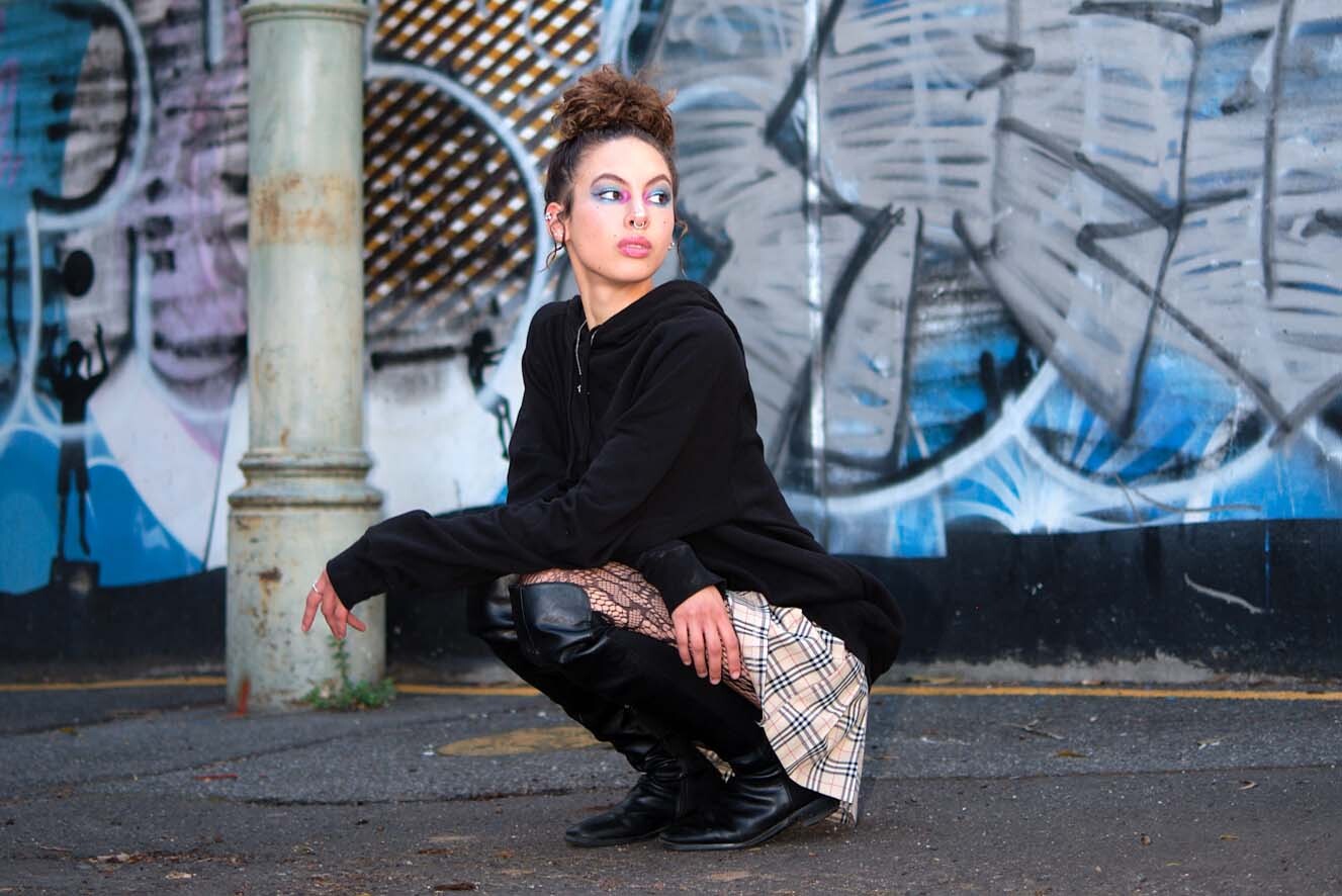 Young woman crouching in the street. Young woman crouching in the street.