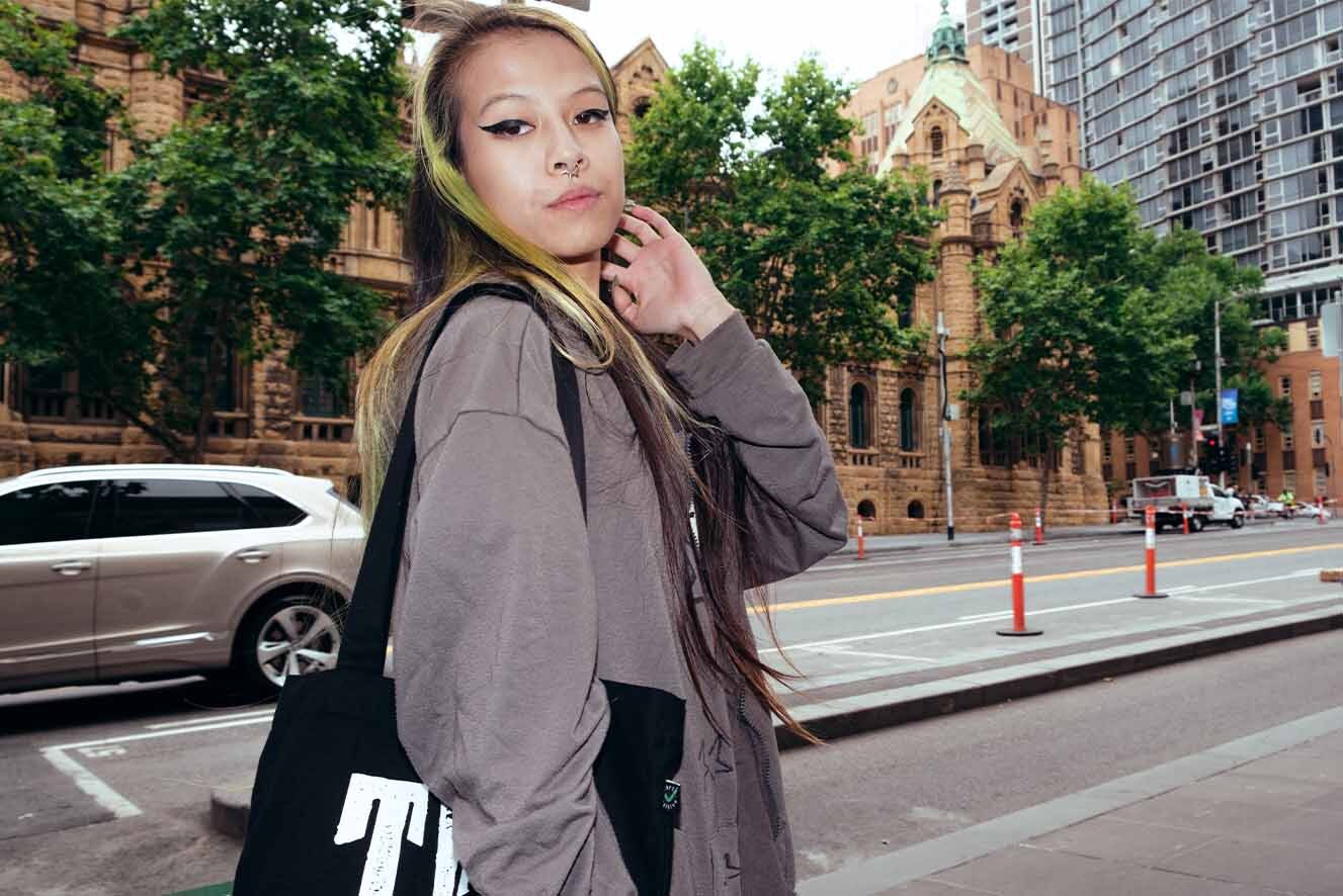 A young woman holding a The Line tote bag. A young woman holding a The Line tote bag.
